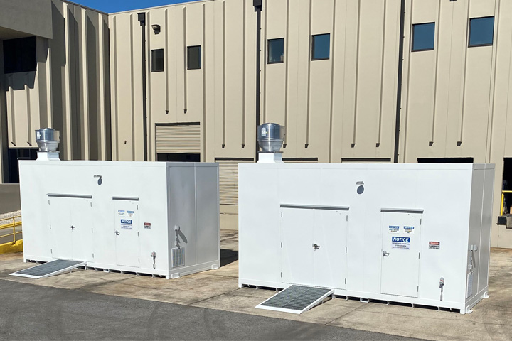 Two white hazardous material storage units outside of Integrated Metal Products building