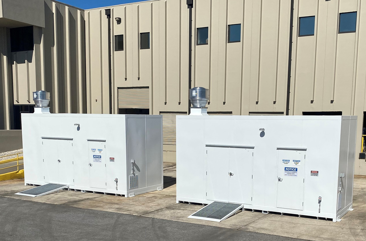 Two white hazardous material storage units outside of Integrated Metal Products building