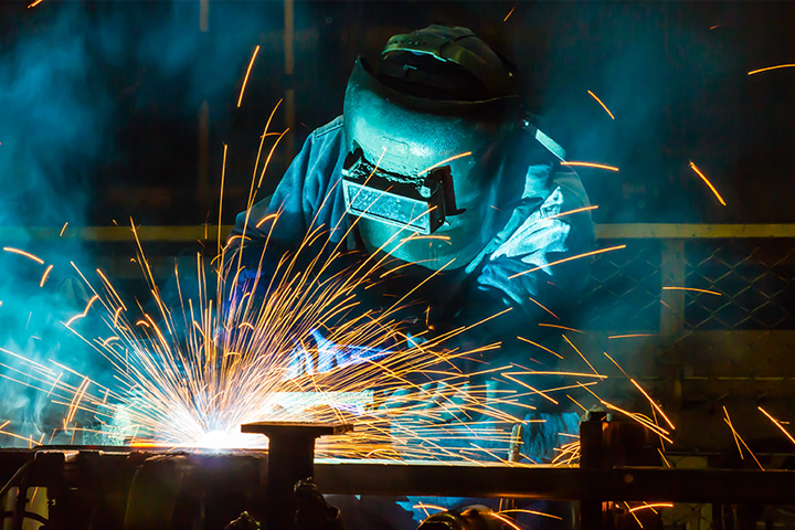 Professional operator welding cut metal together