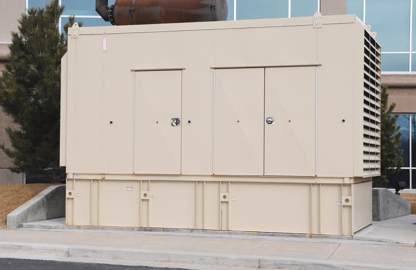 Beige power generater in front of a commerical building