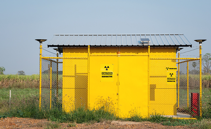 Yellow hazardous material storage building in front of a corn field