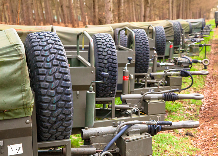 Row of mobile military application trailers parked outside