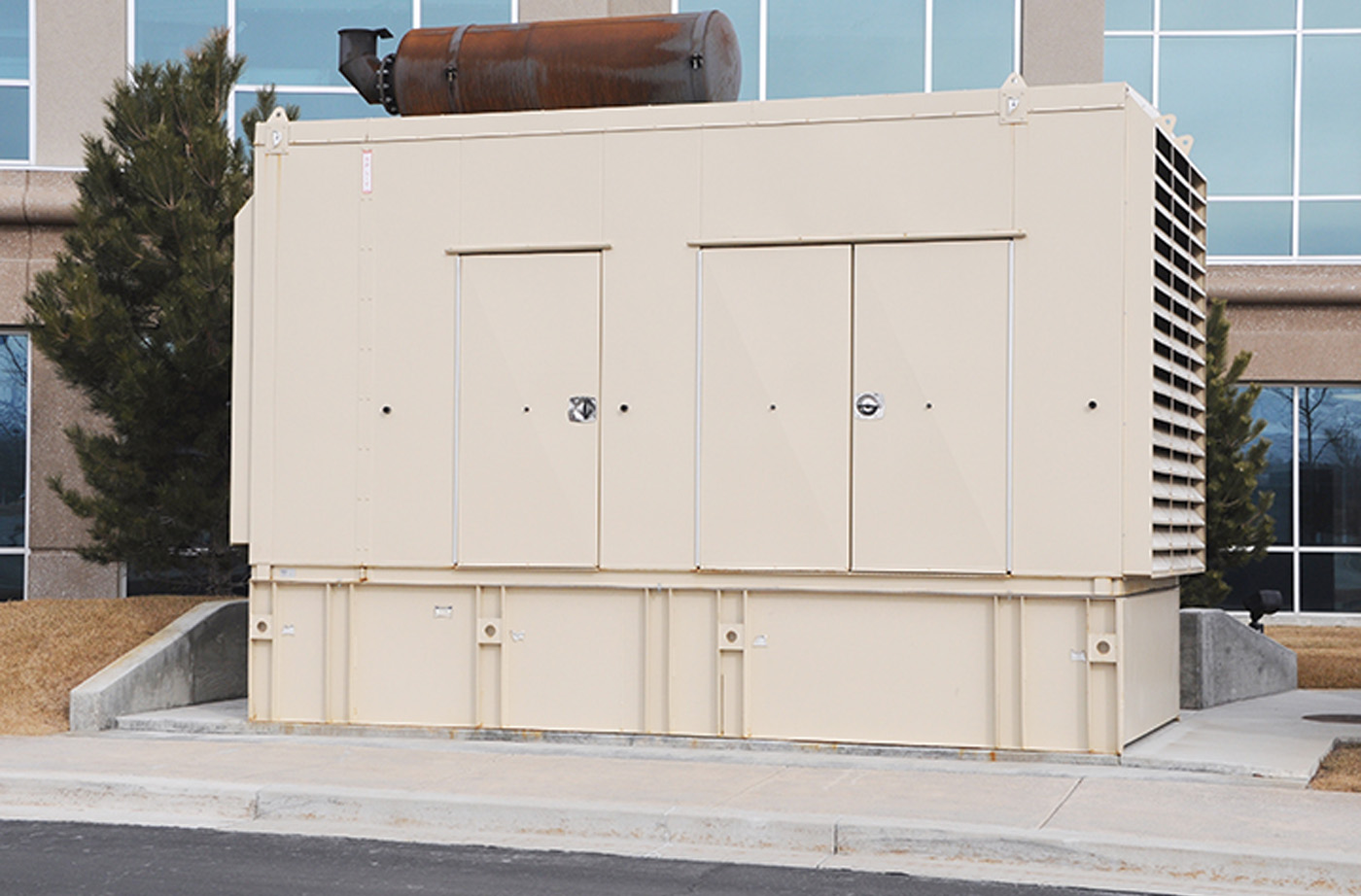 Beige power generator in front of a commercial building