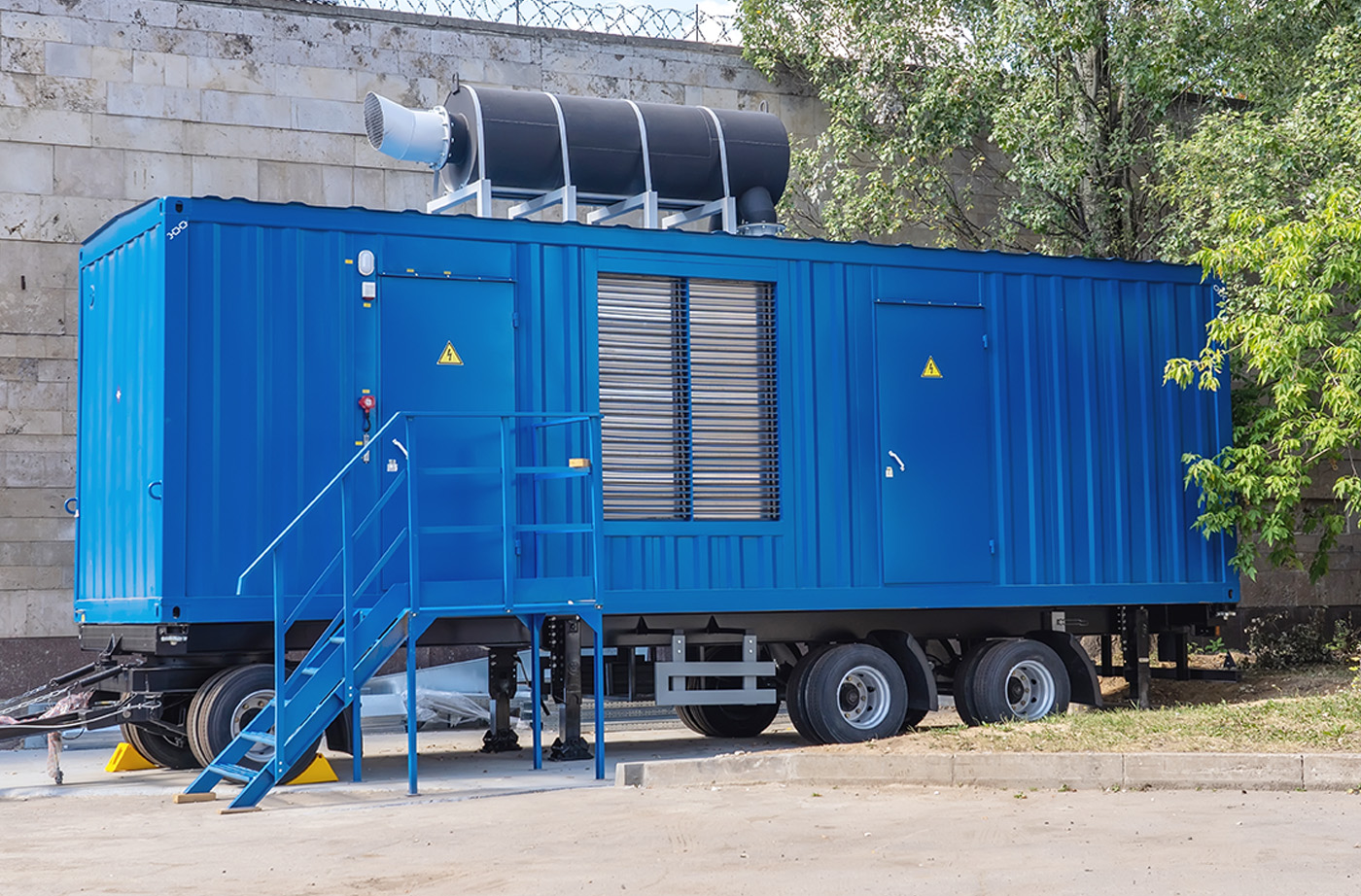 Blue power generation mobile united parked in front of a brick wall