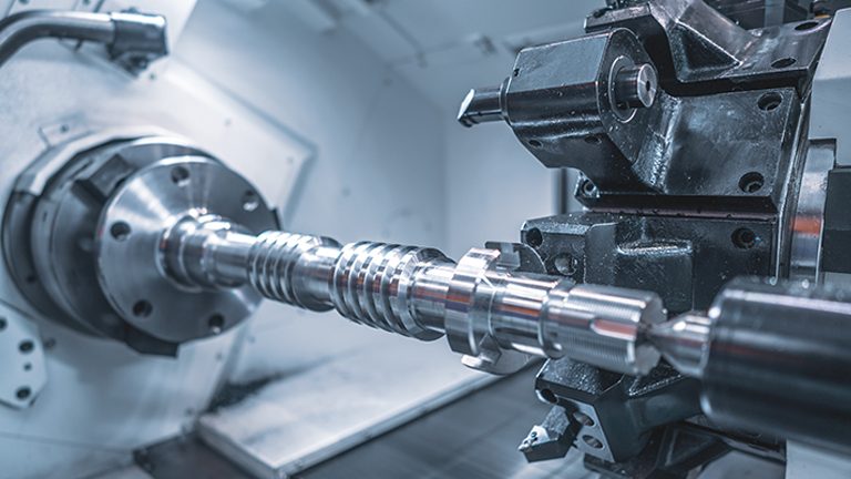 Machine cutting a piece of chrome metal