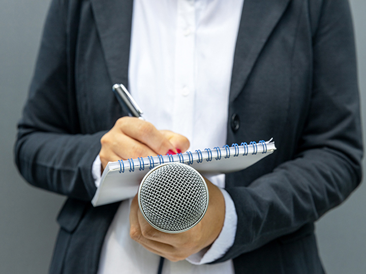 Person taking notes during a press conference